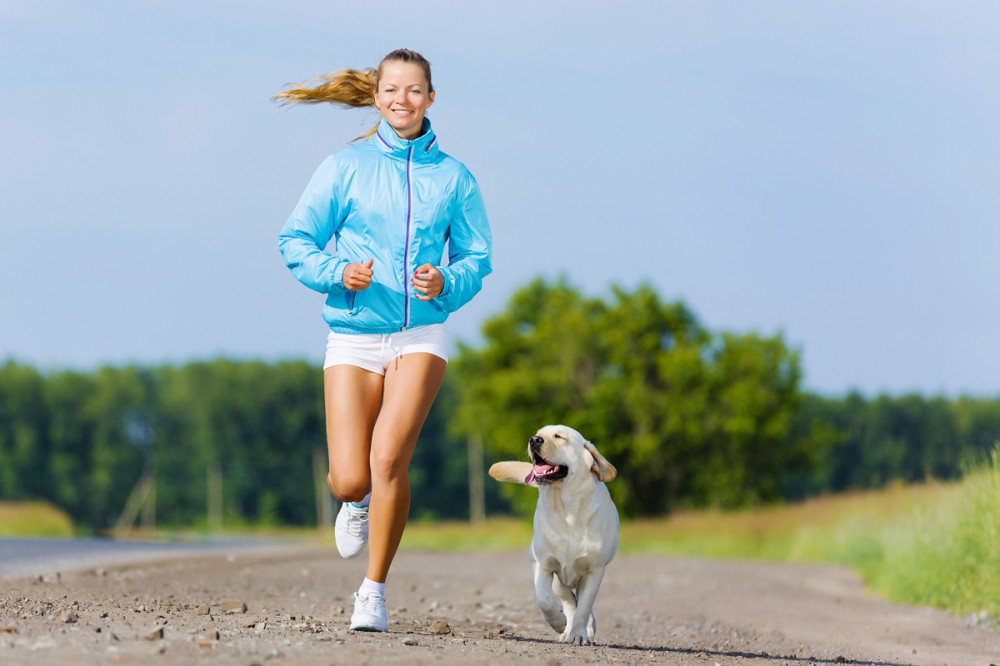 szőke lány fut a golden retrieverrel