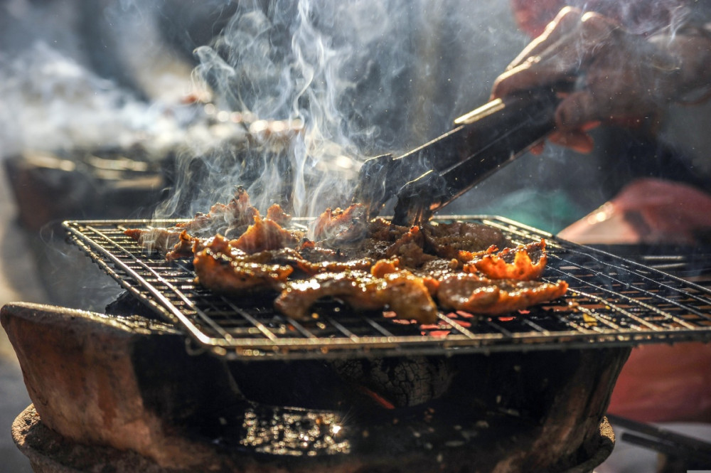 grillen sülő húsokat forgatnak